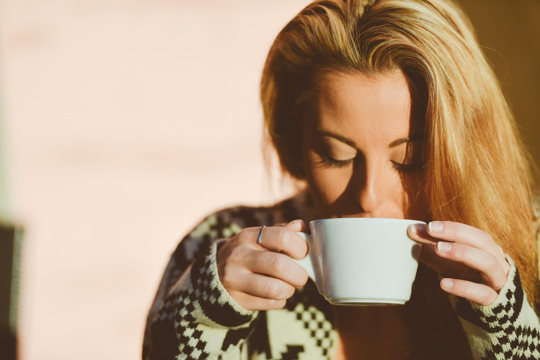 A woman looking relaxed sipping coffee